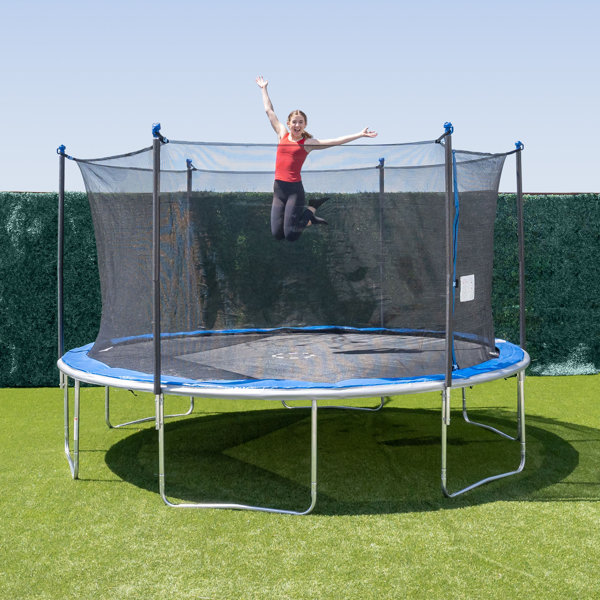 A girl jumping on a backyard spring trampoline